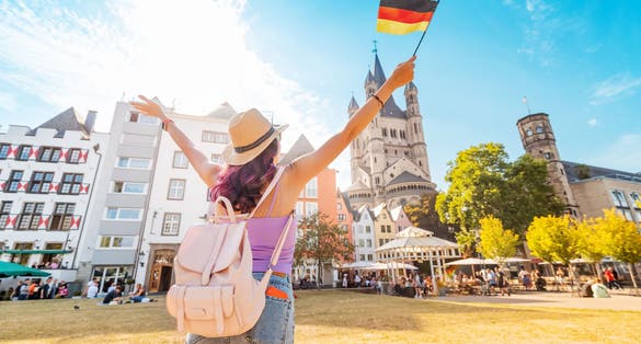 Photo of young happy tourist with a German flag at the old town or Altstadt in Cologne fish market square.