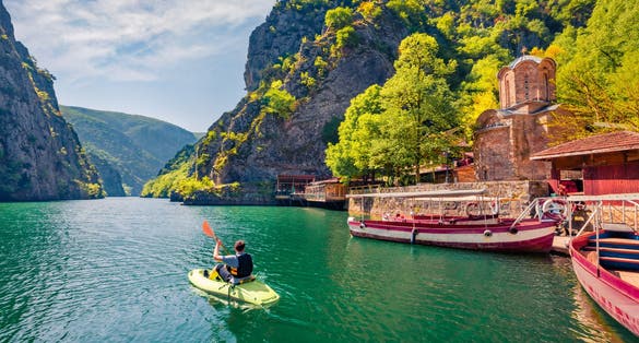 Tourist kayaking on the Matka Canyon. Picturesque morning scene of North Macedonia, Europe. Traveling concept background.