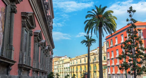 photo of Colorful and beautiful architecture with palm trees in front of the National Archaeological Museum in Naples, Italy.