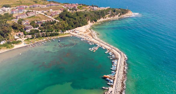 Aerial photo of the beautiful small town and seaside resort of Obzor in Bulgaria showing the fishing and marina side of the town showing fishing boats and the small sunny beach
