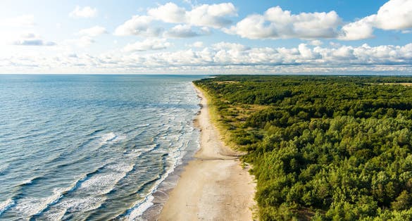Aerial view of the Baltic Sea shore line near Klaipeda city, Lithuania. Beautiful sea coast on sunny summer day.