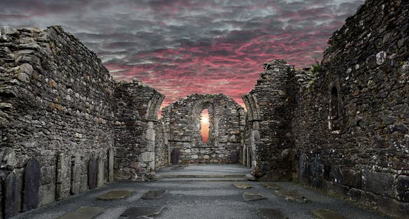 Monastic cemetery of Glendalough, Ireland. Famous ancient monastery while sunset in the wicklow mountains with a beautiful graveyard from the 11th century.