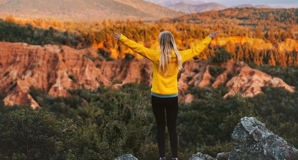 Photo of woman hiking outdoor raised hands enjoying Gjipe canyon in Albania.
