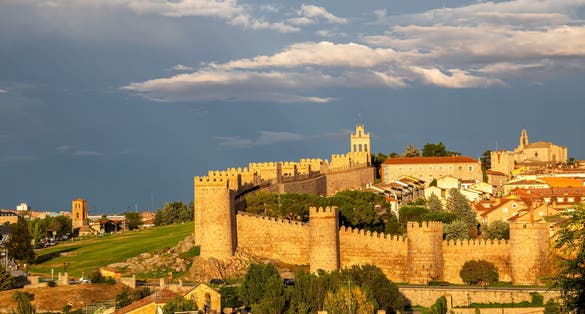 photo of view of Sunset with cloudy sky over the medieval walled city, Avila, Spain.