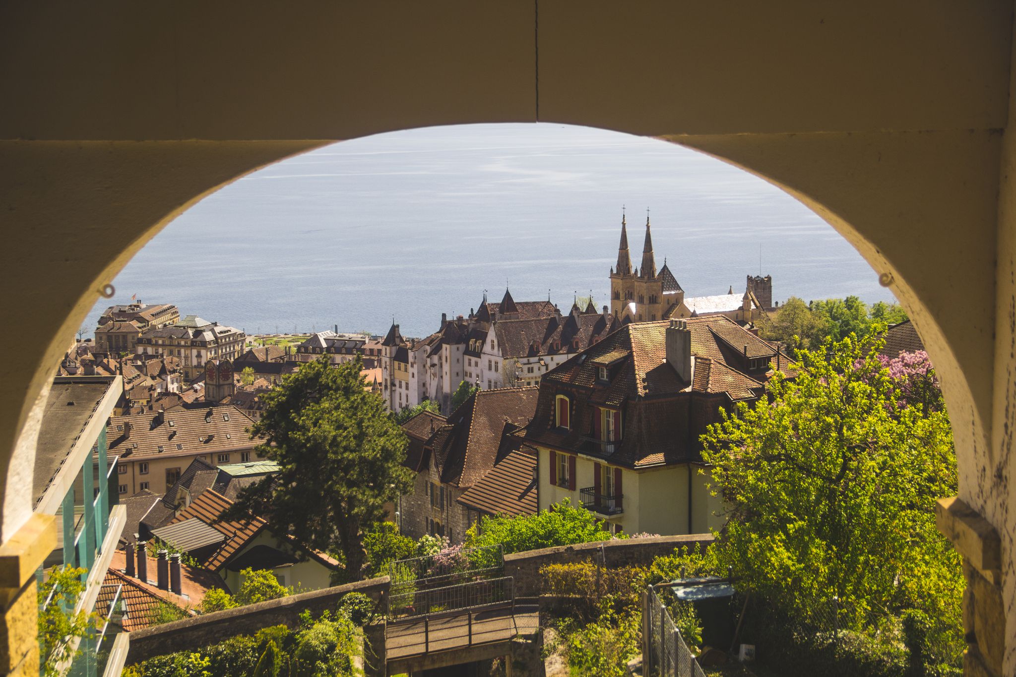 photo of Neuchâtel Castle in Switzerland viewed from above, framed by yellow walls.