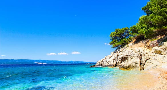 Photo of Laguna beautiful beach surrounded by rocks and forests, Pisak Split Dalmatia, Croatia.