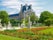 Photo of Corner of the Tuileries Garden with flower bed and alley with sculptures in Paris in springtime, France.