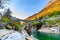 photo of two arches stone bridge soars over turquoise water stream of Valle Verzasca named Ponte dei Salti in canton of Ticino, Switzerland.