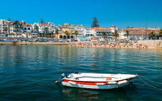 Photo of aerial view over People Crowd Having Fun On Beach And Over Cascais City In Portugal.