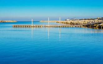 Photo of beach chairs, on a sandy, shoreline, in Giulianova, Italy.
