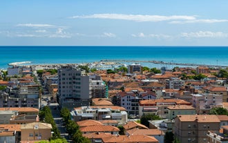 Photo of beach chairs, on a sandy, shoreline, in Giulianova, Italy.