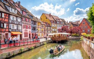Photo of traditional half-timbered houses on picturesque canals in La Petite France in the medieval fairytale town of Strasbourg, France.