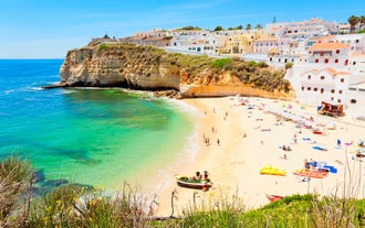 Photo of wide sandy beach in white city of Albufeira, Algarve, Portugal.
