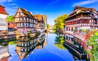 Photo of traditional half-timbered houses on picturesque canals in La Petite France in the medieval fairytale town of Strasbourg, France.