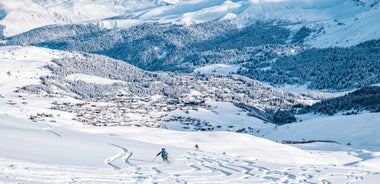 photo of beautiful snow capped mountains with Arosa village in France. Back country skier in the foreground leave their tracks in the deep snow.
