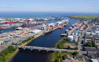 Photo of aerial view of Aberdeen as River Dee flows in a curve to the North Sea showing Duthie Park with bridge and traffic from south.