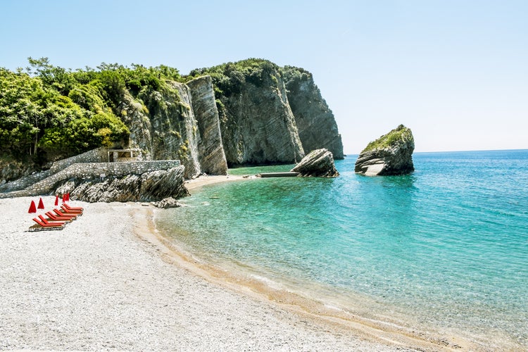 Photo of the beach and the cliffs on the island of St. Nicholas in Budva, Montenegro.