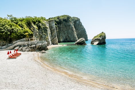 Photo of the beach and the cliffs on the island of St. Nicholas in Budva, Montenegro.