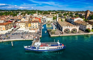 Photo of aerial view of superb Malcesine Mediterranean cityscape with colorful buildings and boats, yachts in the bay, lake Garda, Italy.