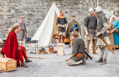 Actors put on a Medieval theatrical performance for tourist at the quayside of the seaside town of Conway outside Conway castle.