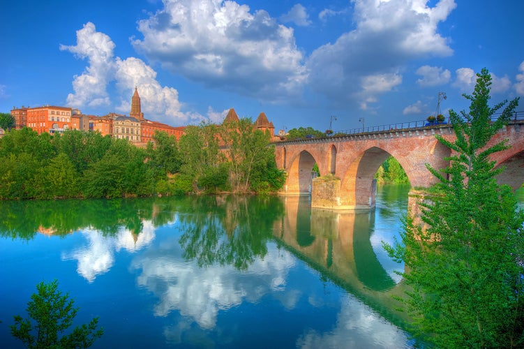 photo of view of The river at Montauban, south west France, seen on a calm day with the sky reflected, Montaubanz, France.