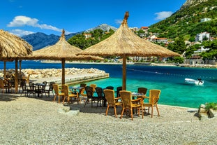 Photo of panorama and landscape of Makarska resort and its harbour with boats and blue sea water, Croatia.