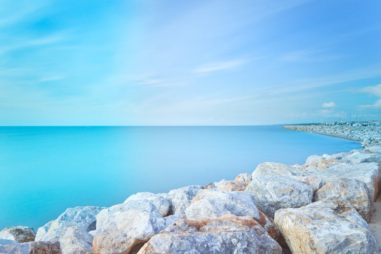 photo of view of San Vincenzo Marina harbor breakwater rocks bay. Long exposure photography. Sea travel destination, Tuscany, Italy.