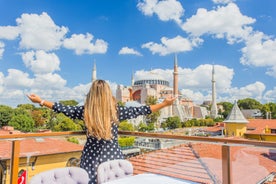 Touristic sightseeing ships in Golden Horn bay of Istanbul and mosque with Sultanahmet district against blue sky and clouds. Istanbul, Turkey during sunny summer day.