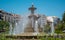 photo of the monumental fountain of battles during a sunny summer day in the city of Granada, Spain.