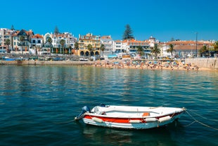 Photo of aerial view over People Crowd Having Fun On Beach And Over Cascais City In Portugal.