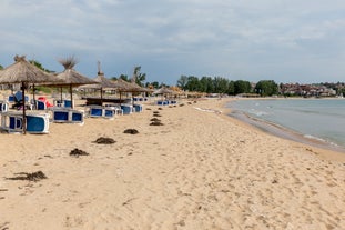 Photo of Saint Anastasia Island in Burgas bay, Black Sea, Bulgaria. Lighthouse tower and old wooden buildings on rocky coast.