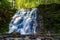 photo of Silverfallet staircase waterfall in lush forest in Björkliden, Sweden.