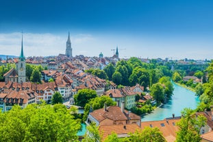 Geneva skyline cityscape, French-Swiss in Switzerland. Aerial view of Jet d'eau fountain, Lake Leman, bay and harbor from the bell tower of Saint-Pierre Cathedral. Sunny day blue sky.