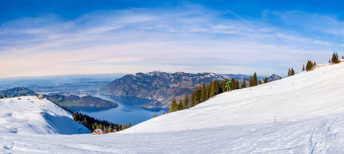 Panorama of Klewenalp mountains and Lake Lucerne or Vierwaldstattersee from mountain peak covered with snow. Popular ski resort in Swiss Alps and winter sport attraction in Switzerland in winter.