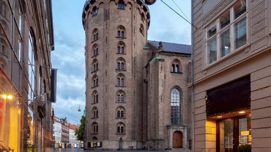 The Round Tower in Copenhagen, a historic brick structure, surrounded by shops and quiet streets at dusk..jpg