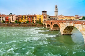 Photo of aerial view of Verona historical city centre, Ponte Pietra bridge across Adige river, Verona Cathedral, Duomo di Verona, red tiled roofs, Veneto Region, Italy.