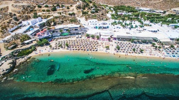 Photo of panoramic aerial view of the popular Platis Gialos beach on the Greek island of Mykonos with turquoise sea, Greece.