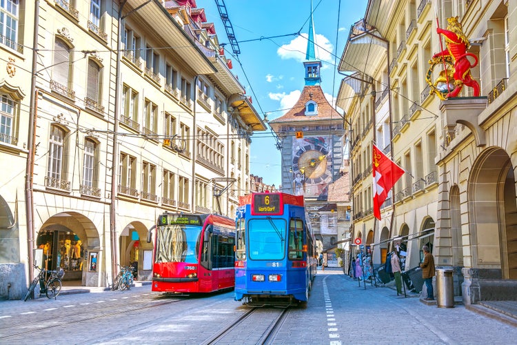 Photo of streets with shopping area and Zytglogge astronomical clock tower in the historic old medieval city centre of Bern, Switzerland.