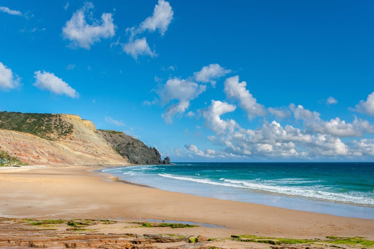 Photo of beach and rocky coast of Praia da Luz in the Algarve in Portugal.