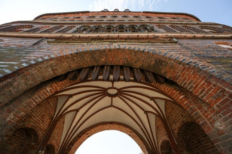 Vault in the entrance arch of the Lubeck Holstentor (Holsten gate), famous historic landmark in gothic brick architecture from medieval times, seen from below on a sunny day