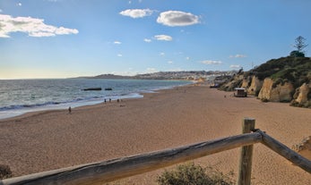 Photo of wide sandy beach in white city of Albufeira, Algarve, Portugal.