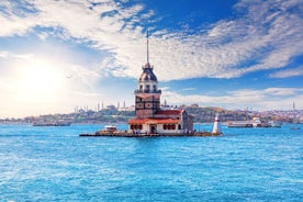 Touristic sightseeing ships in Golden Horn bay of Istanbul and mosque with Sultanahmet district against blue sky and clouds. Istanbul, Turkey during sunny summer day.