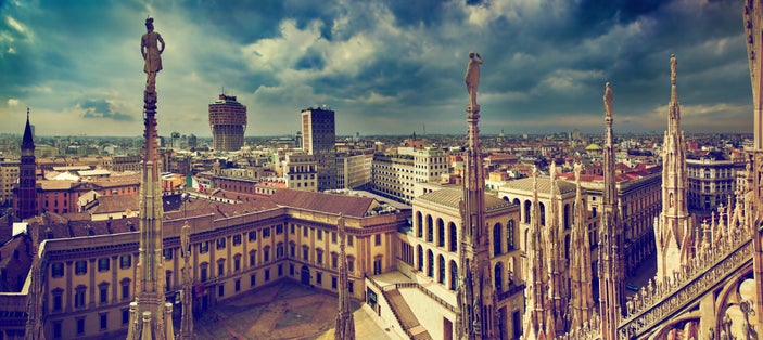 photo of Milan, Italy panorama. View from Milan Cathedral. Royal Palace of Milan - Palazzo Realle and Velasca Tower in the background.