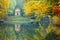 photo of Reflection of a little temple in a pond of the Park of Monza surrounded by yellow autumnal trees, Italy