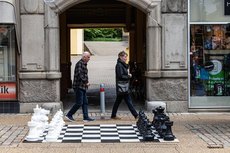 A couple walking by a chess set on the pavement Hjorring, Denmark .jpg