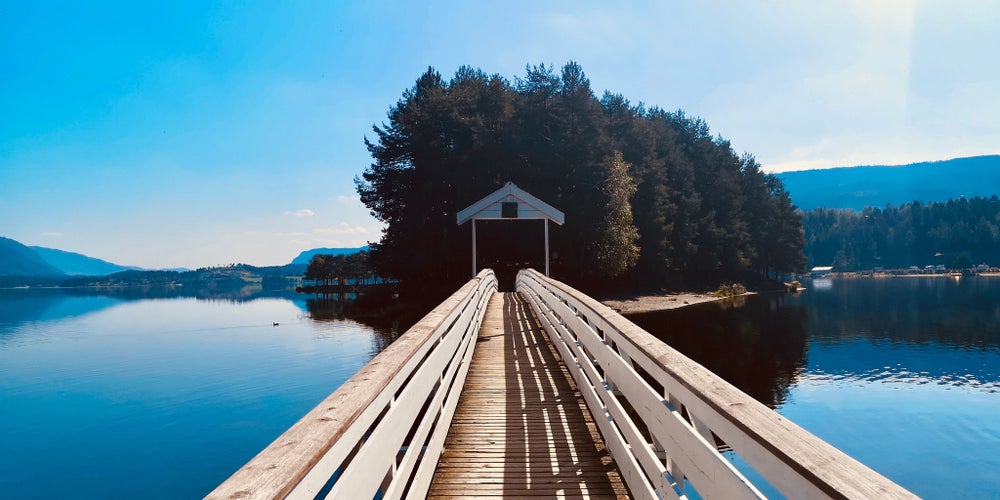 photo of view of wooden bridge connectedto a small island in Fagernes, Norway. 