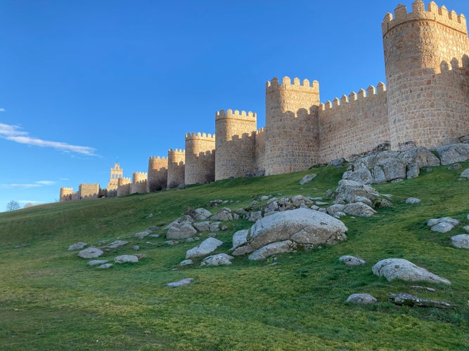 photo of view of Ávila, Spain, is a city in the rolling hill country northwest of Madrid. It’s best known for its intact medieval city walls, with 80-plus crenelated, semicircular towers and 9 gates.