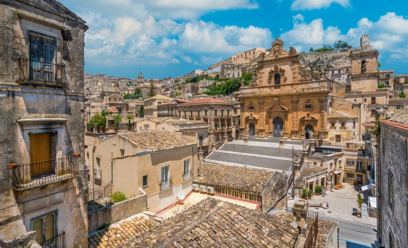 Photo of scenic sight in Ragusa with the Cathedral of San Pietro and the Duomo of San Giorgio in the background, Sicily, southern Italy.