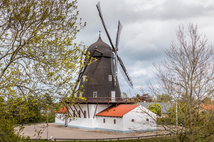 The historic Baunhoj Mill in Grenaa, Denmark. Old mill in black and white colors. mill for grinding grain for flour. cloudy sky in the background.