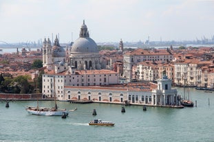 Famous buildings, gondolas and monuments by the Rialto Bridge of Venice on the Grand Canal, Italy.